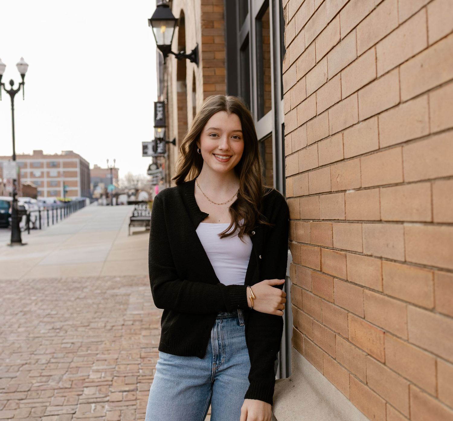 Senior leaning against a pretty brick wall in the Old Market in Omaha for her Senior Photos in Nebraska.