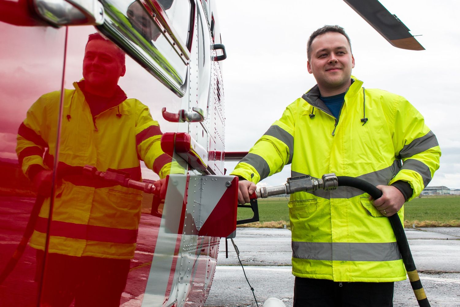 Ground crew in high visibility gear performing maintenance checks on aircraft.