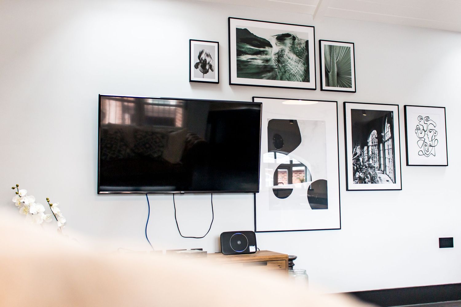 Contemporary wall gallery with black and white framed artwork and photographs.