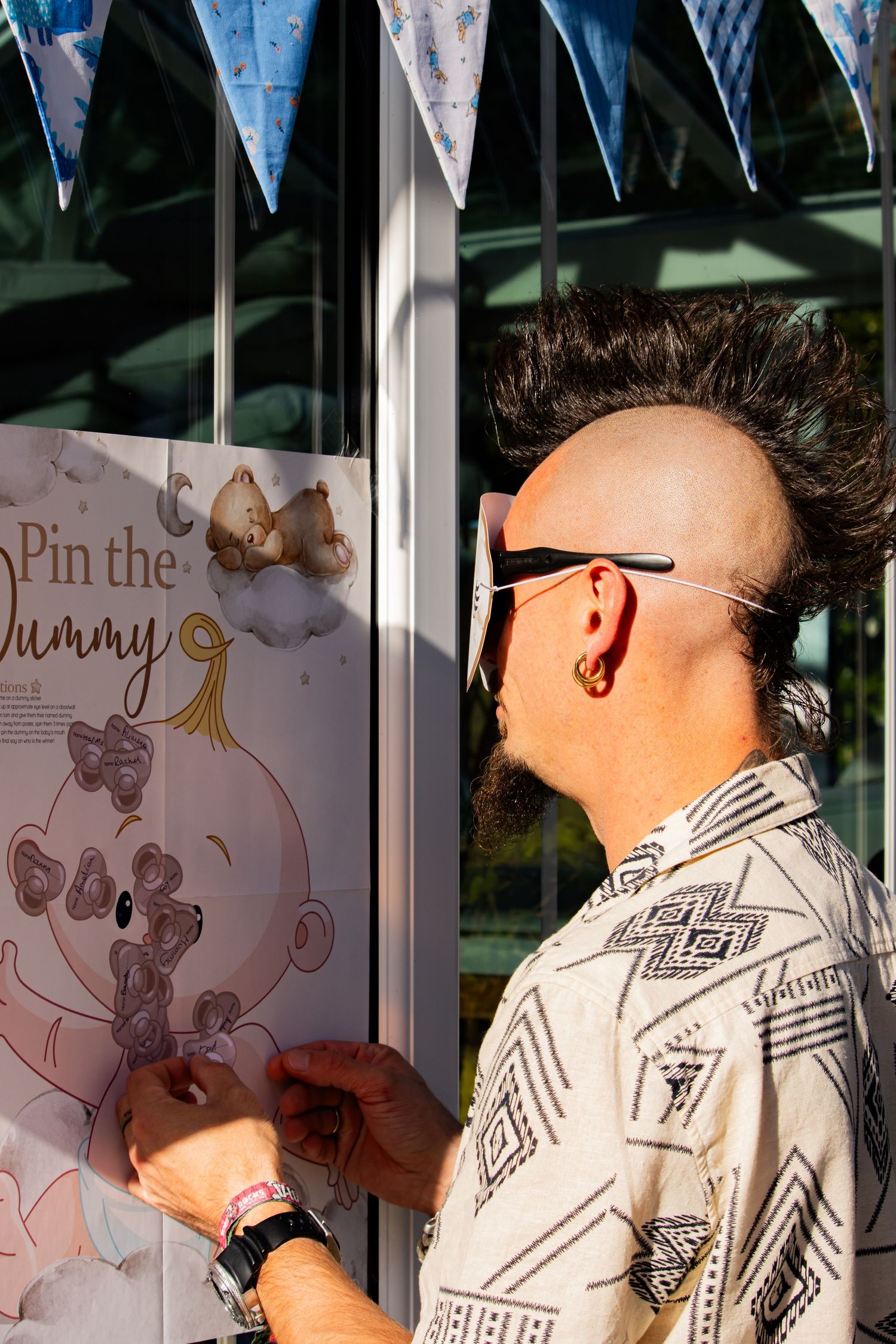 Person playing a baby-themed party game with pin the dummy decoration.