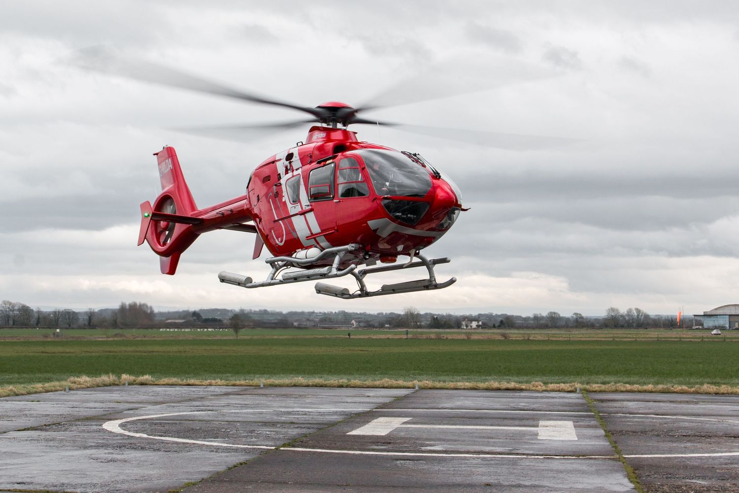 Sequence showing red rescue helicopter taking off from landing pad.