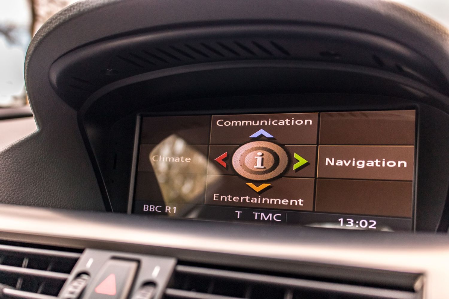 Car dashboard infotainment screen displaying Communication, Navigation, Entertainment, and Climate menu options.