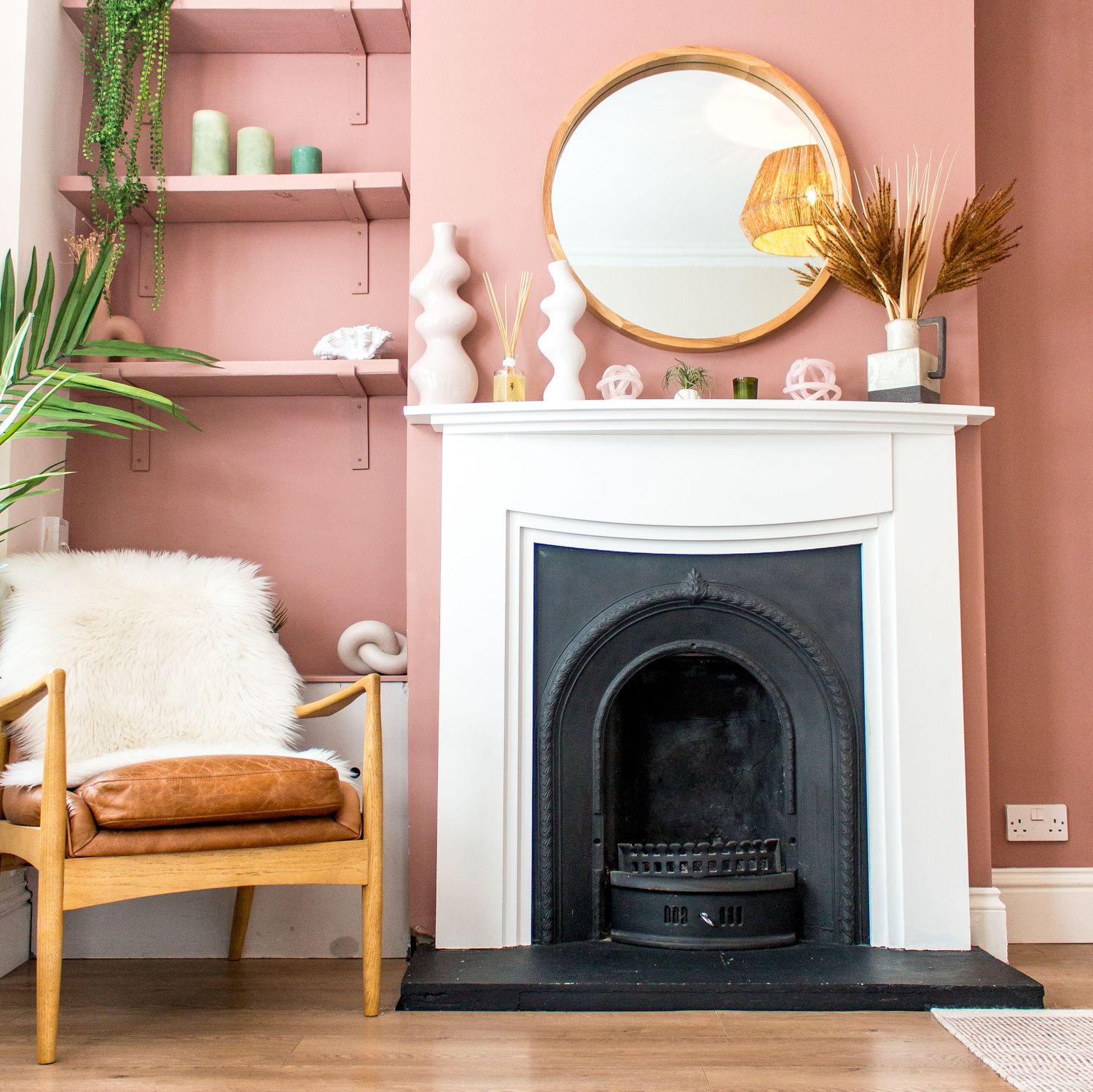 Pink living room with white fireplace, indoor plants, and mid-century modern furniture.
