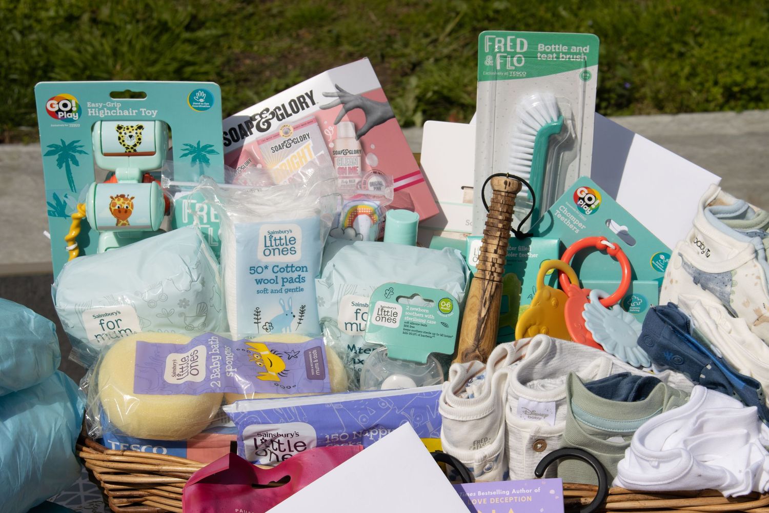 Collection of baby care products and supplies arranged in gift basket.