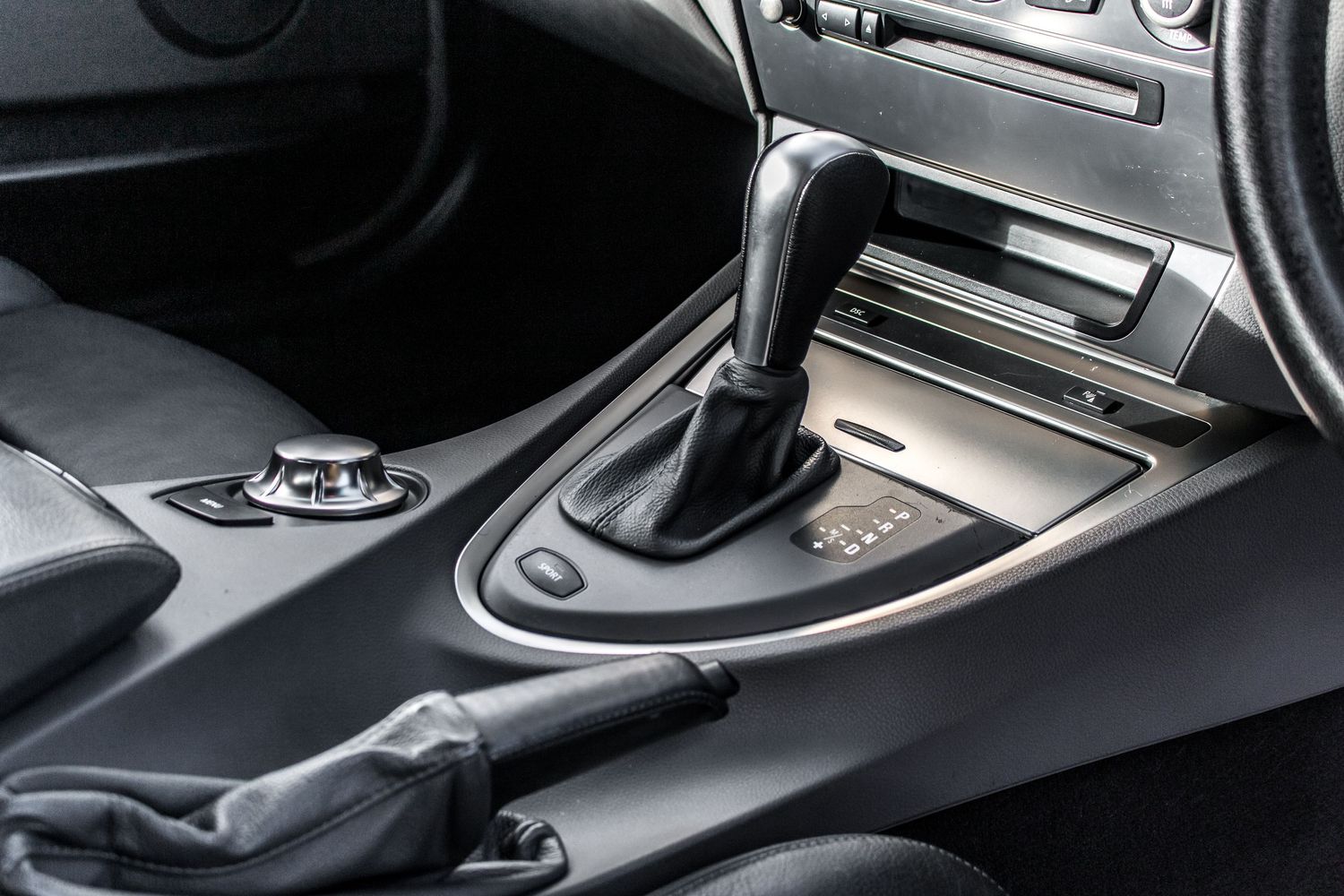 Close-up of a black automatic gear shift in a modern car interior with sleek center console.