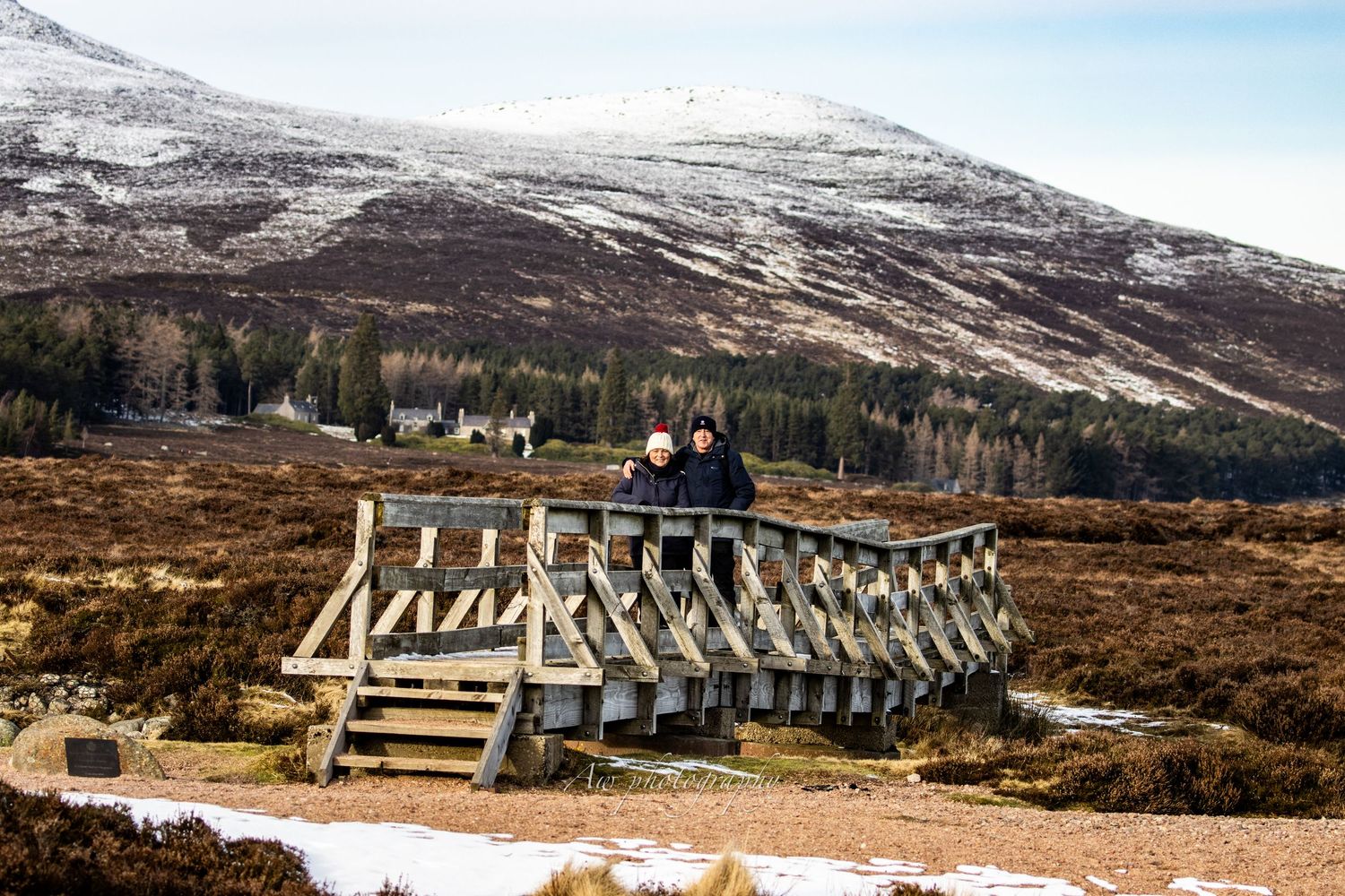 Snow-covered mountain landscape with wooden walkway stretching into distance.