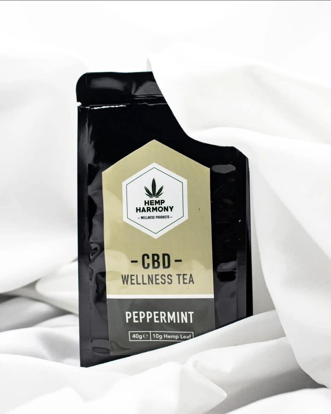 CBD wellness tea packaging in black with peppermint variety label on white background.
