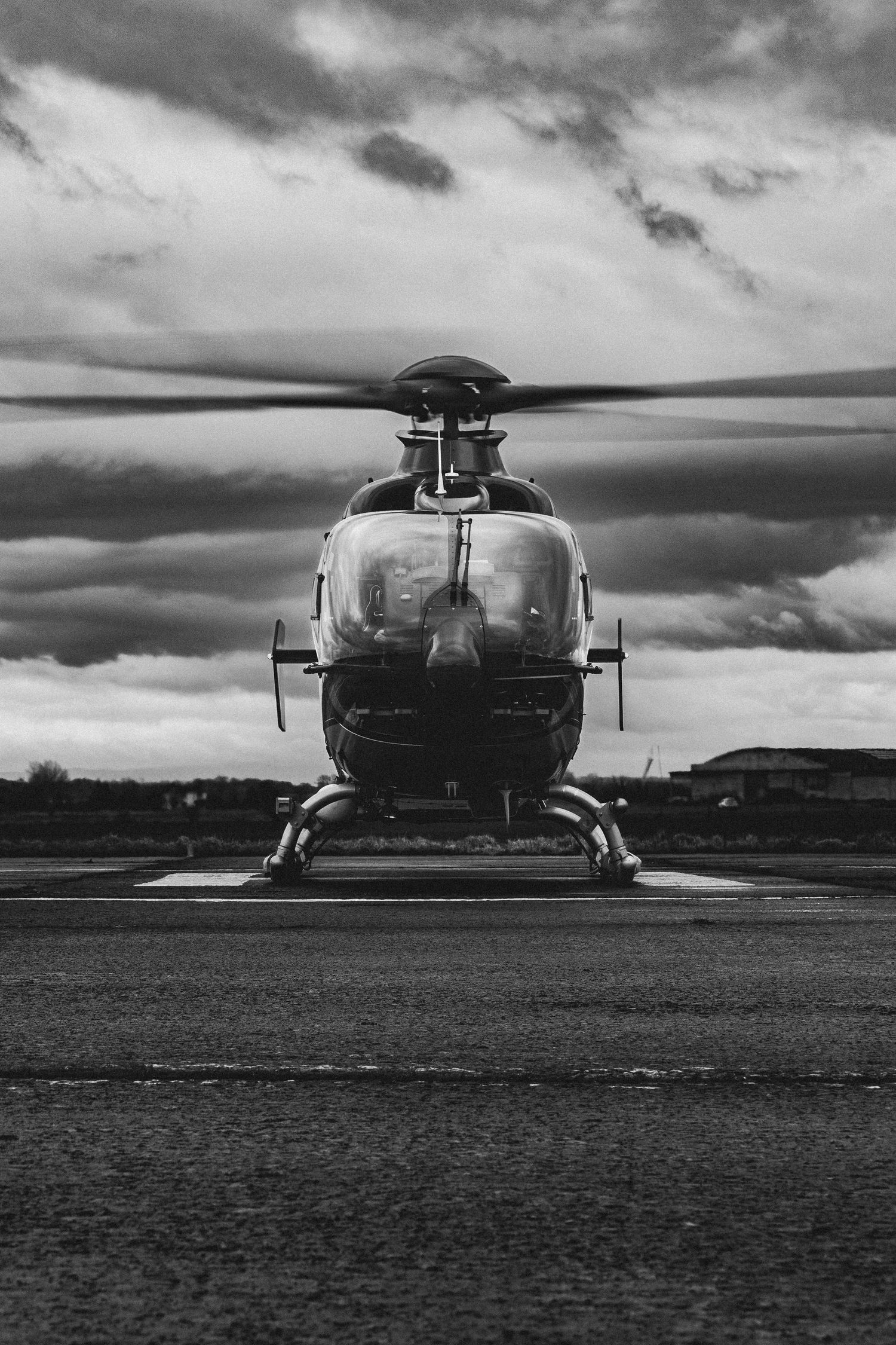 Black and white photograph of military helicopter on landing pad.