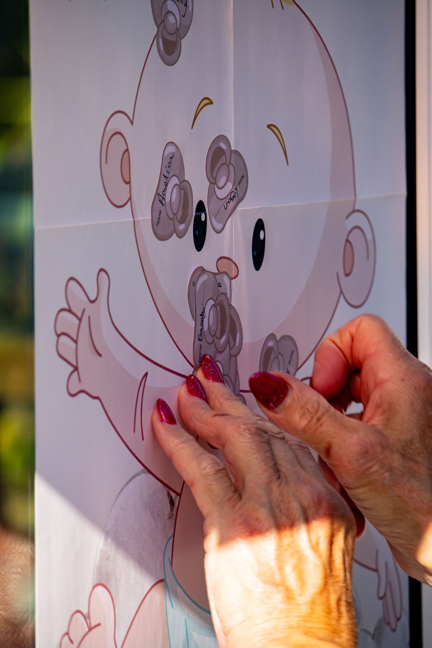 Hands working on a cartoon illustration displayed on a light surface.