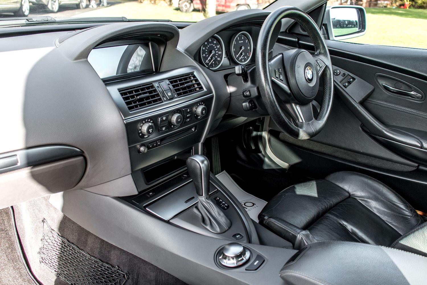 BMW 6 Series convertible interior showing leather seats, gear shift, dashboard, and steering wheel in a right-hand drive configuration.