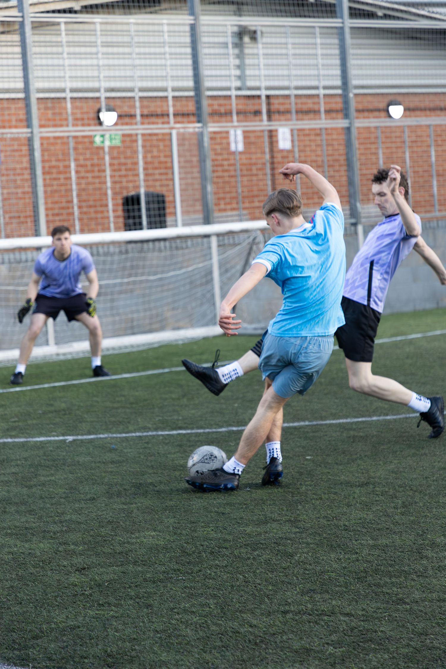 Players in action during an outdoor football match on a London pitch, sports photography by Svntos Photography