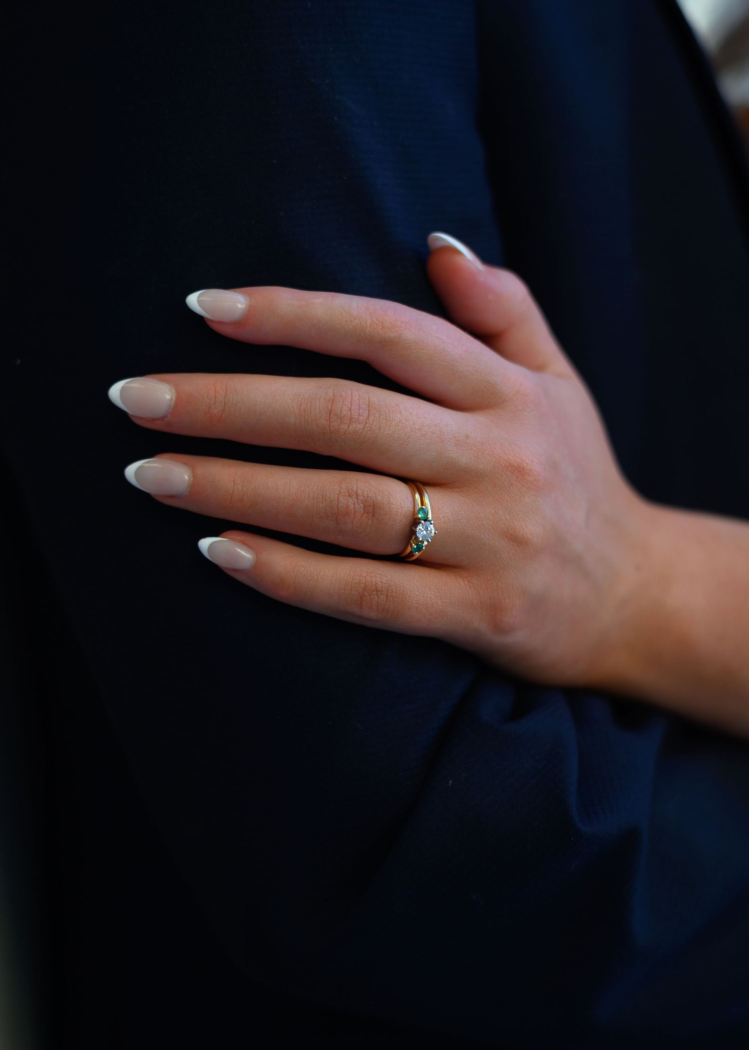 close up of brides hand on grooms arm, engagement ring on finger