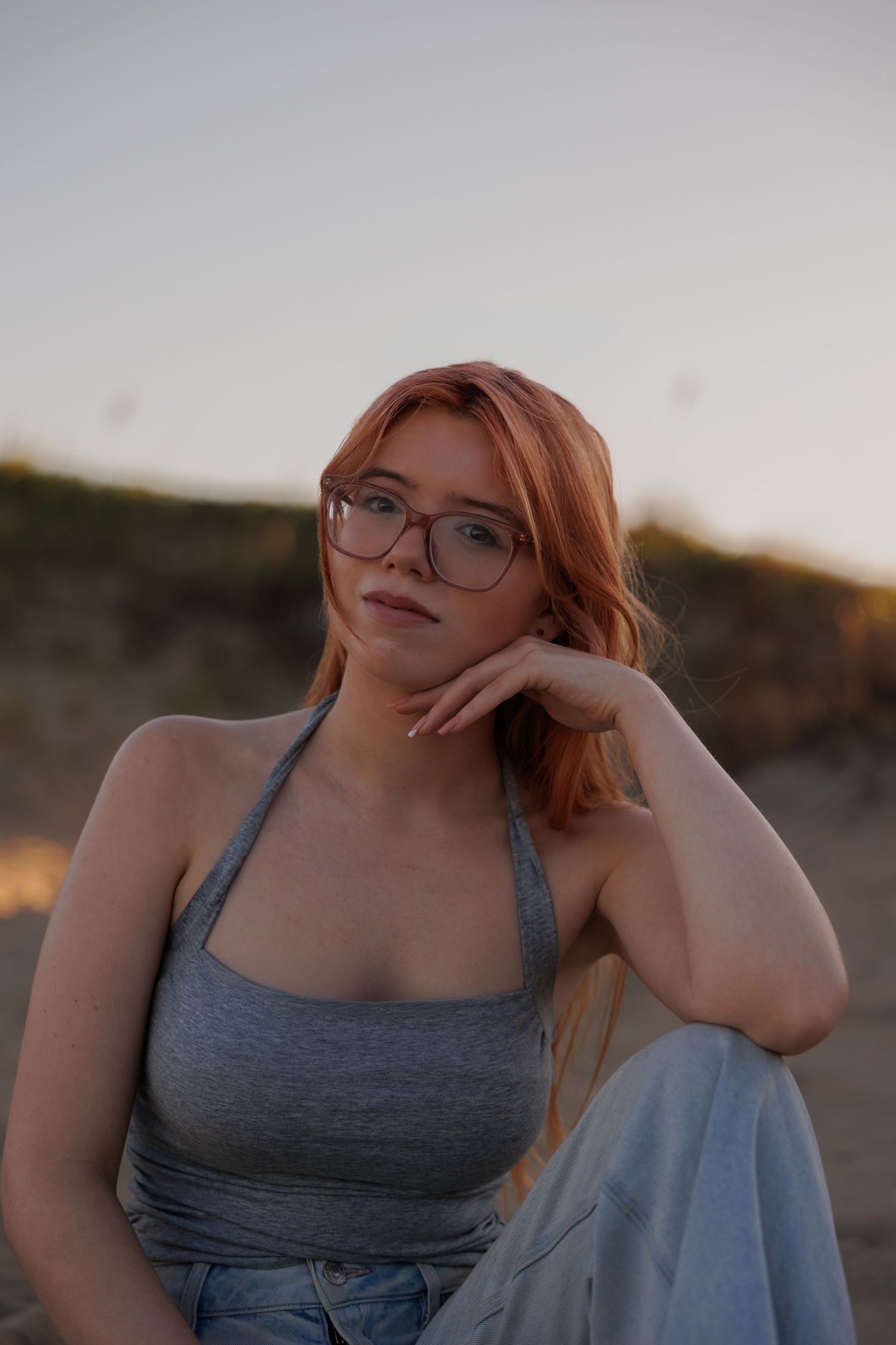 senior sitting on beach looking into camera