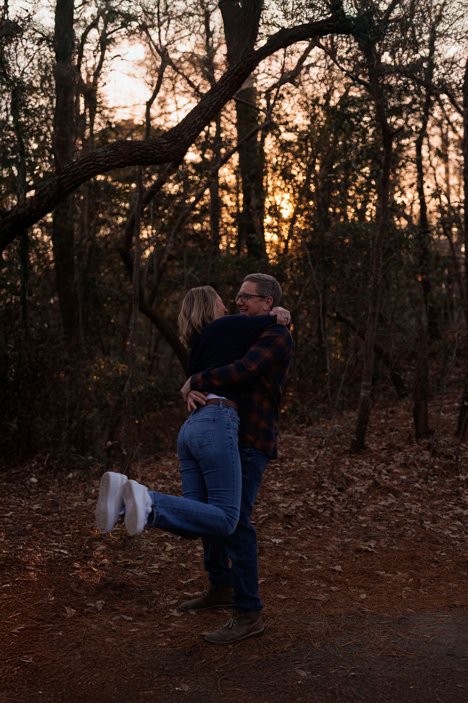 couple spinning in the woods laughing