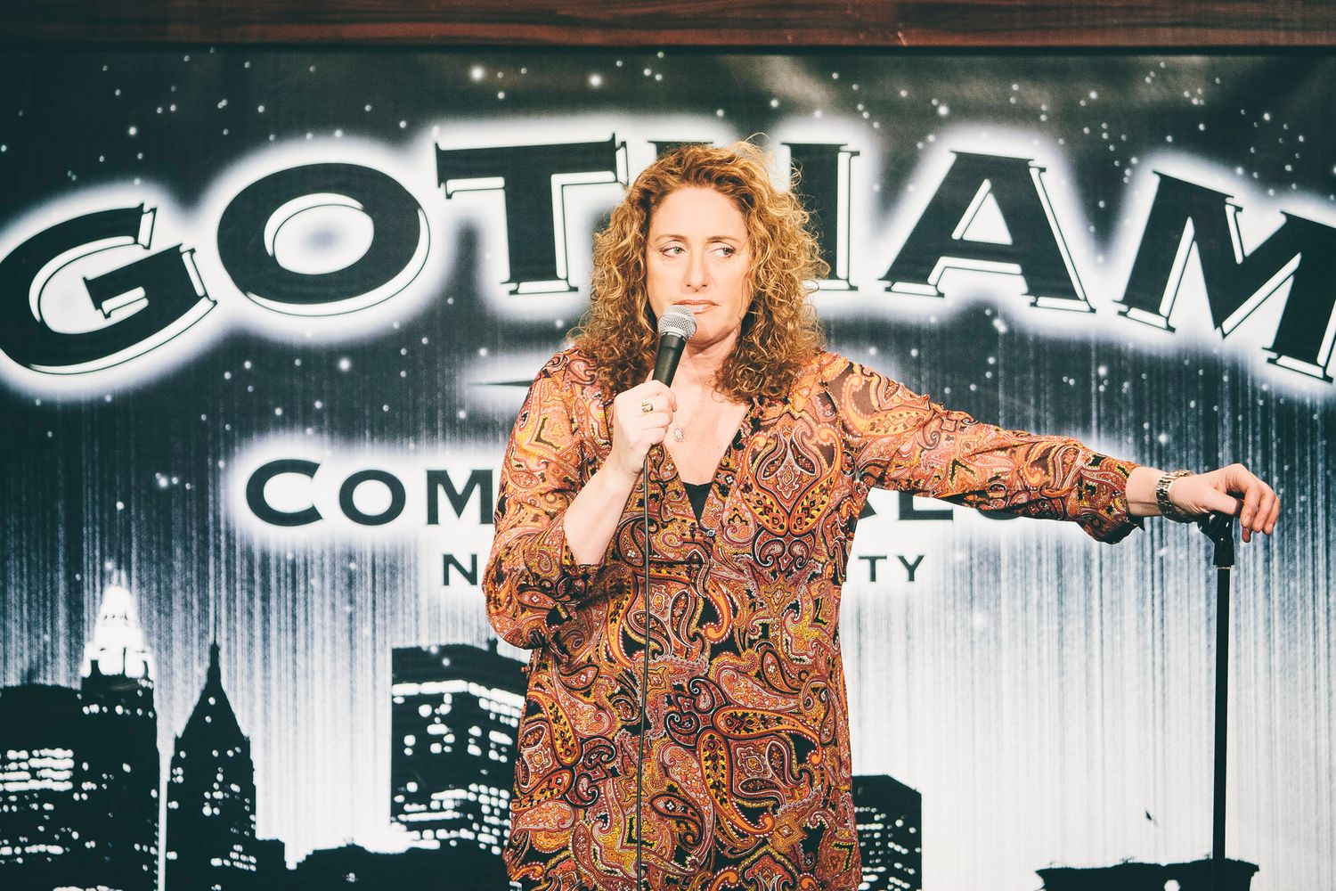 Curly-haired female comedian performing stand-up at Gotham Comedy Club NYC.