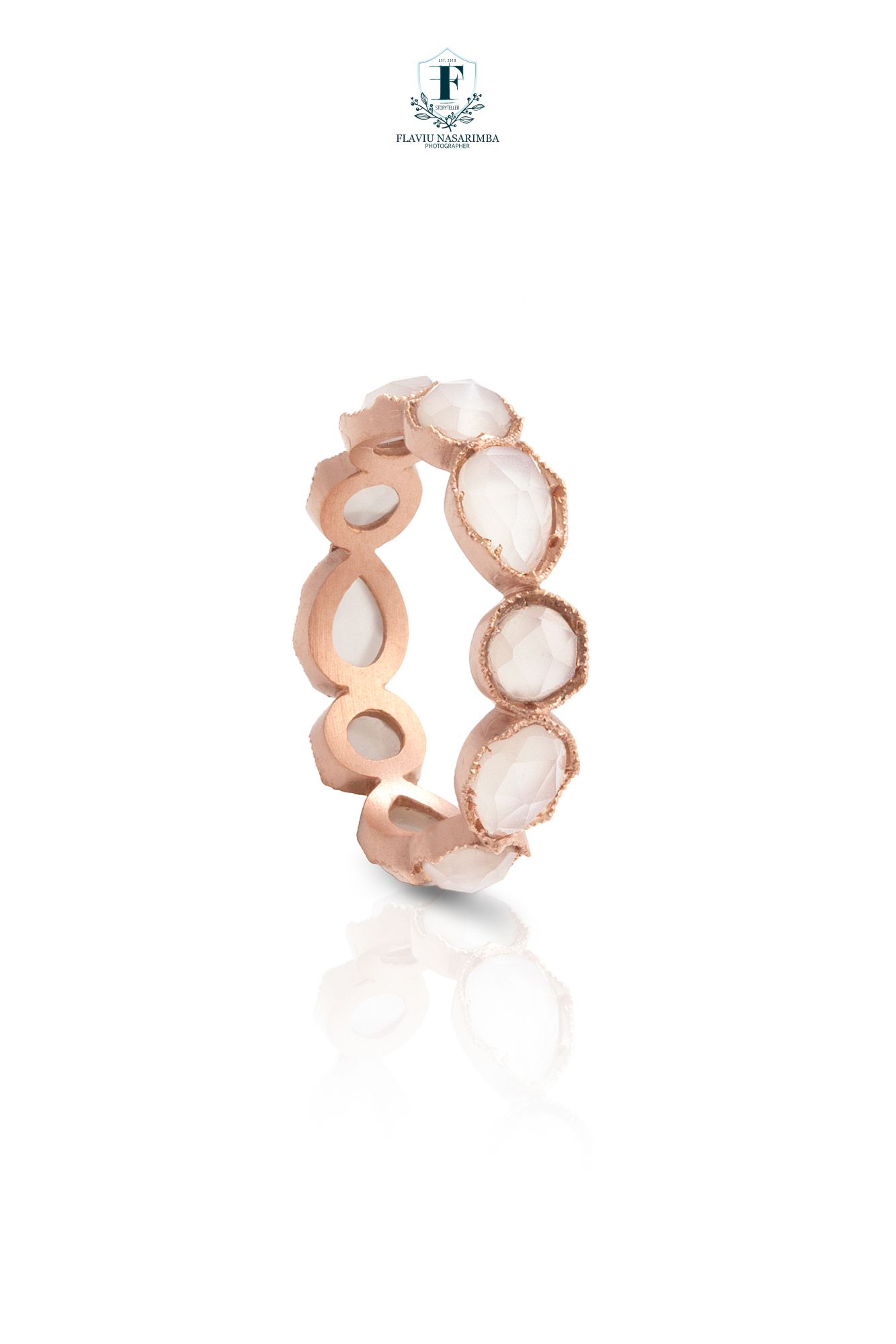 Rose gold eternity band ring featuring alternating oval and teardrop rose quartz stones with milgrain edges.