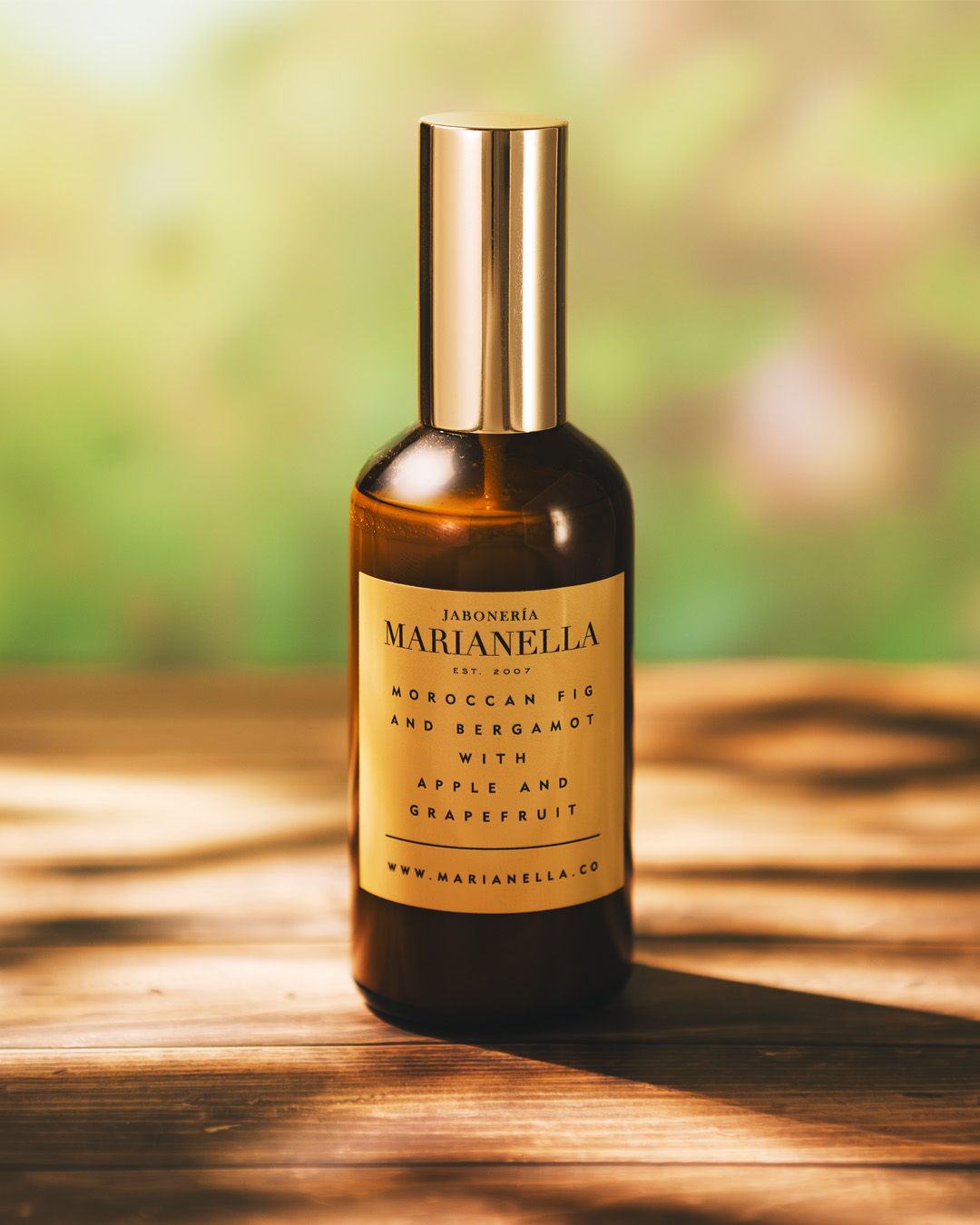 Jaroneria Marianella Moroccan Fig and Bergamot fragrance spray bottle on wooden surface outdoors.