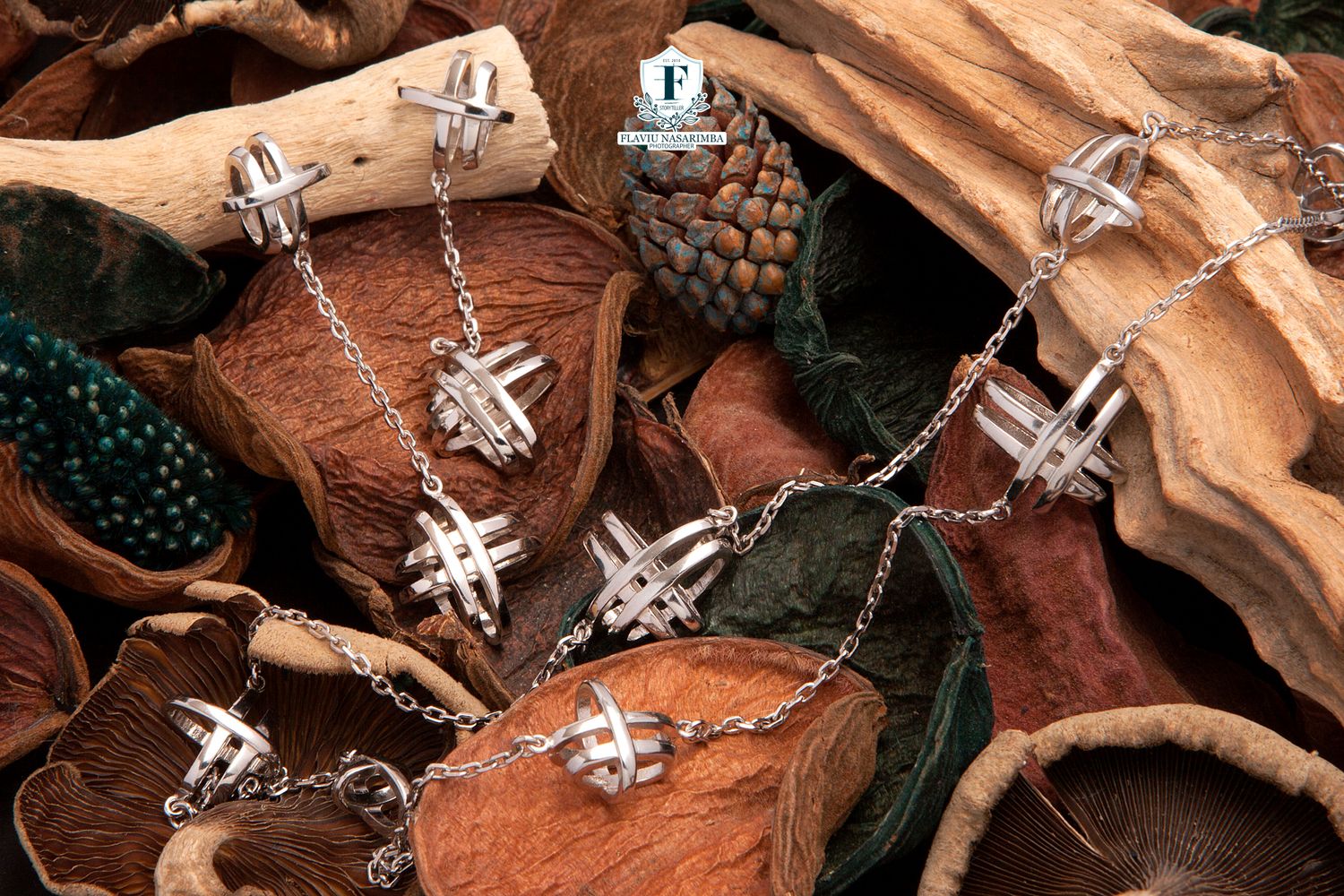Silver cross-hatched pendant necklace and earrings set displayed on autumn leaves and pine cones.