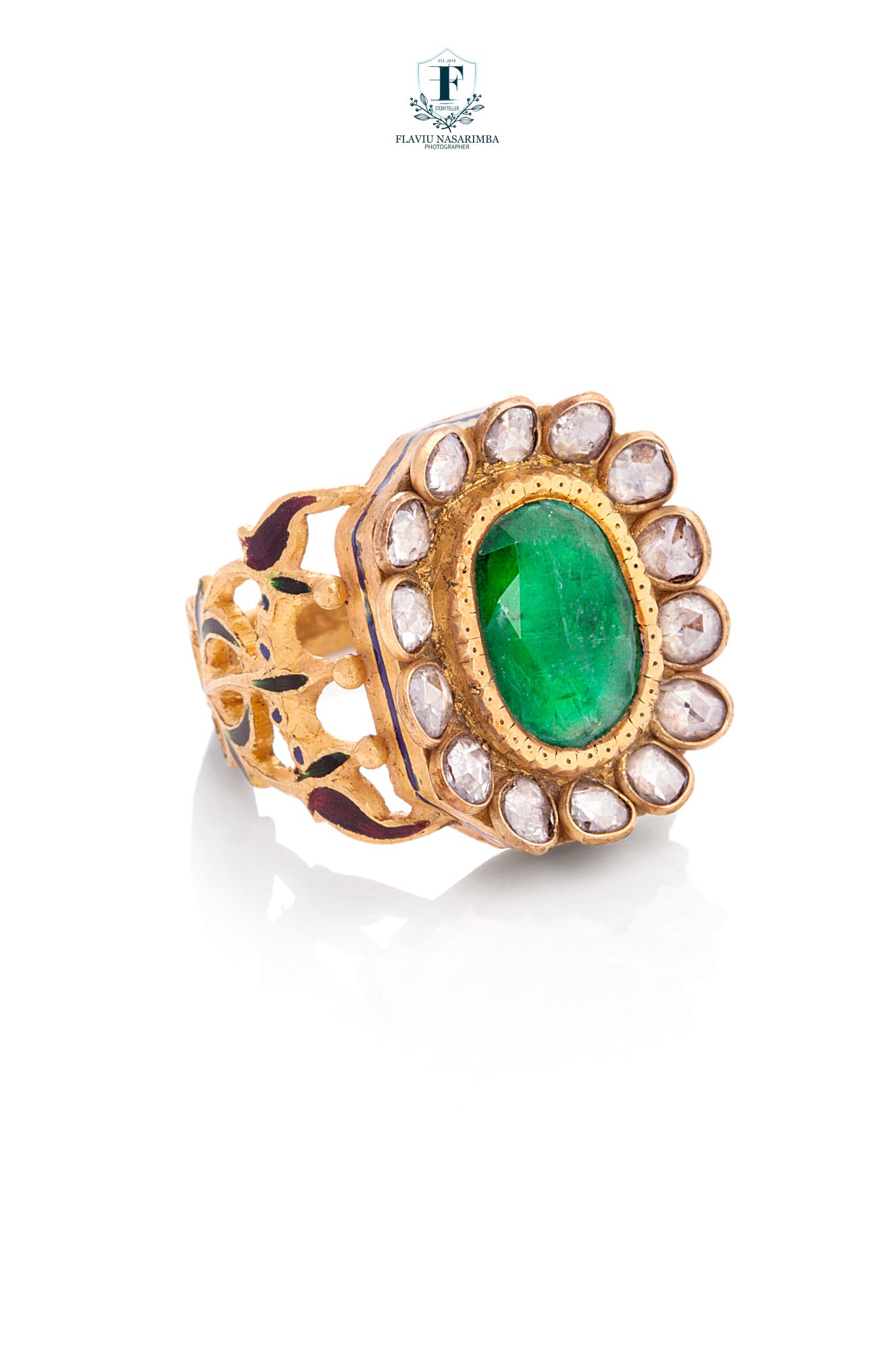 Gold cocktail ring with oval cabochon emerald center stone surrounded by uncut diamond flower halo.