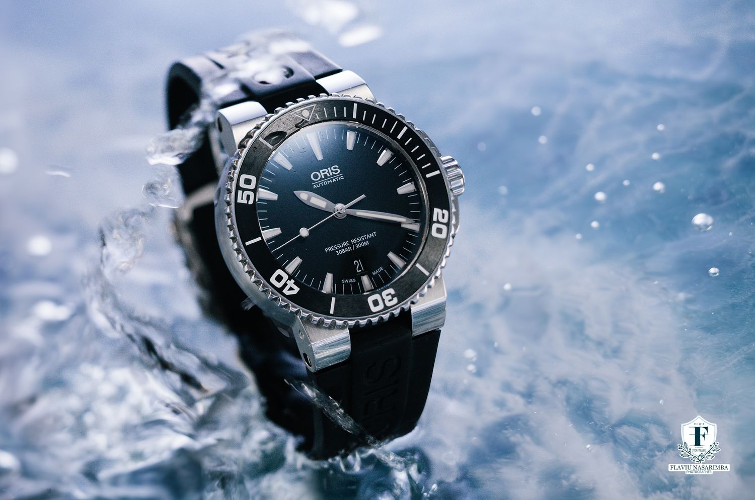 Oris Aquis diver watch with rotating bezel emerging dramatically from splashing water.