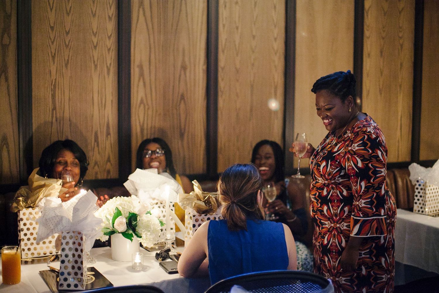 Women celebrating at The Capable Bride wedding planning event with gifts and floral centerpieces.