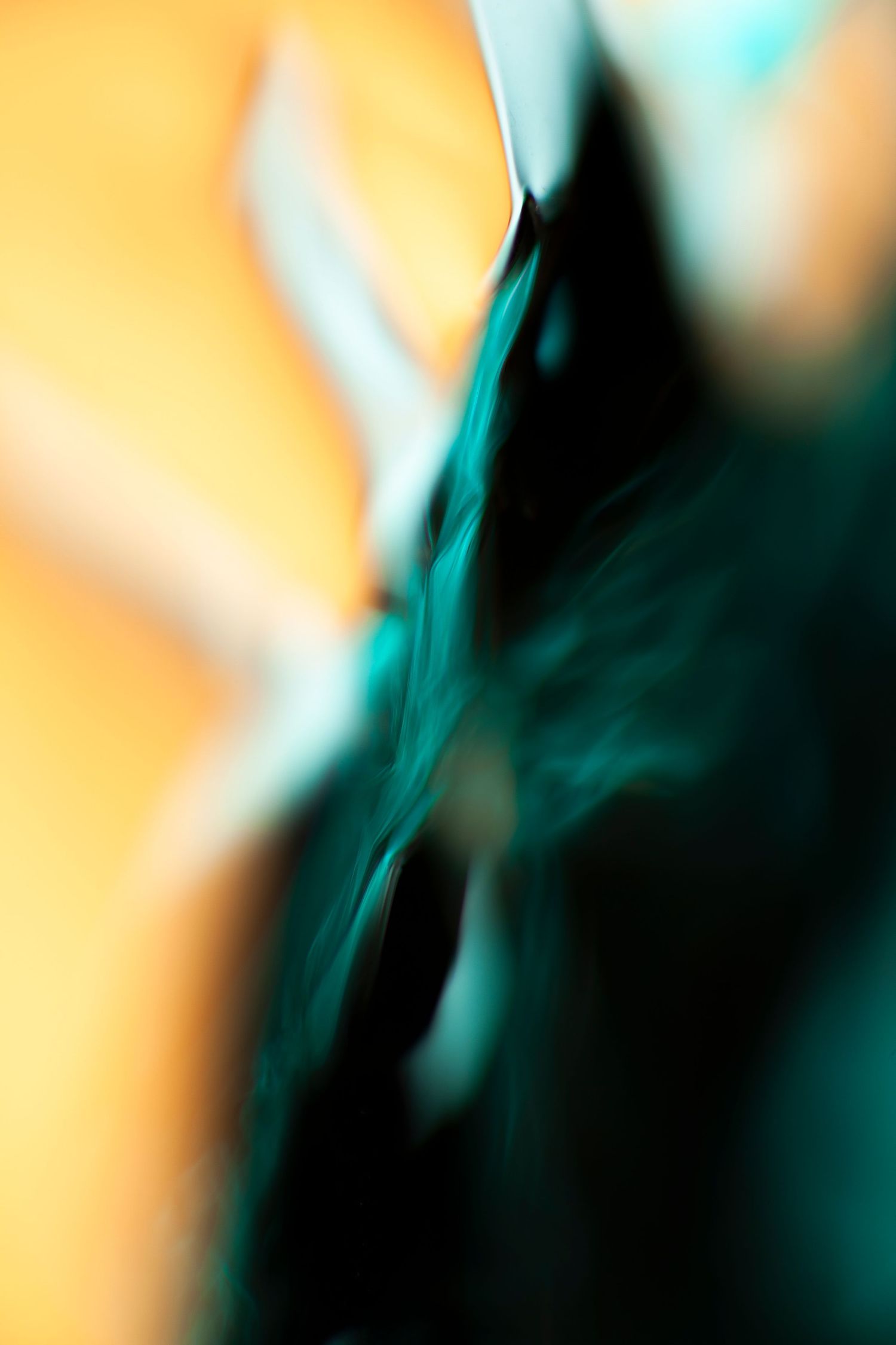 Abstract motion blur art with teal and black swirls against a warm orange background.