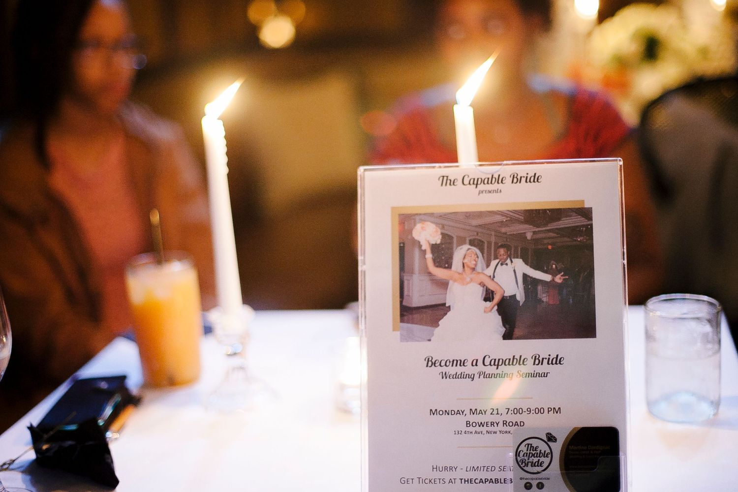 The Capable Bride wedding planner event program displayed on a candlelit table at an elegant dinner event.