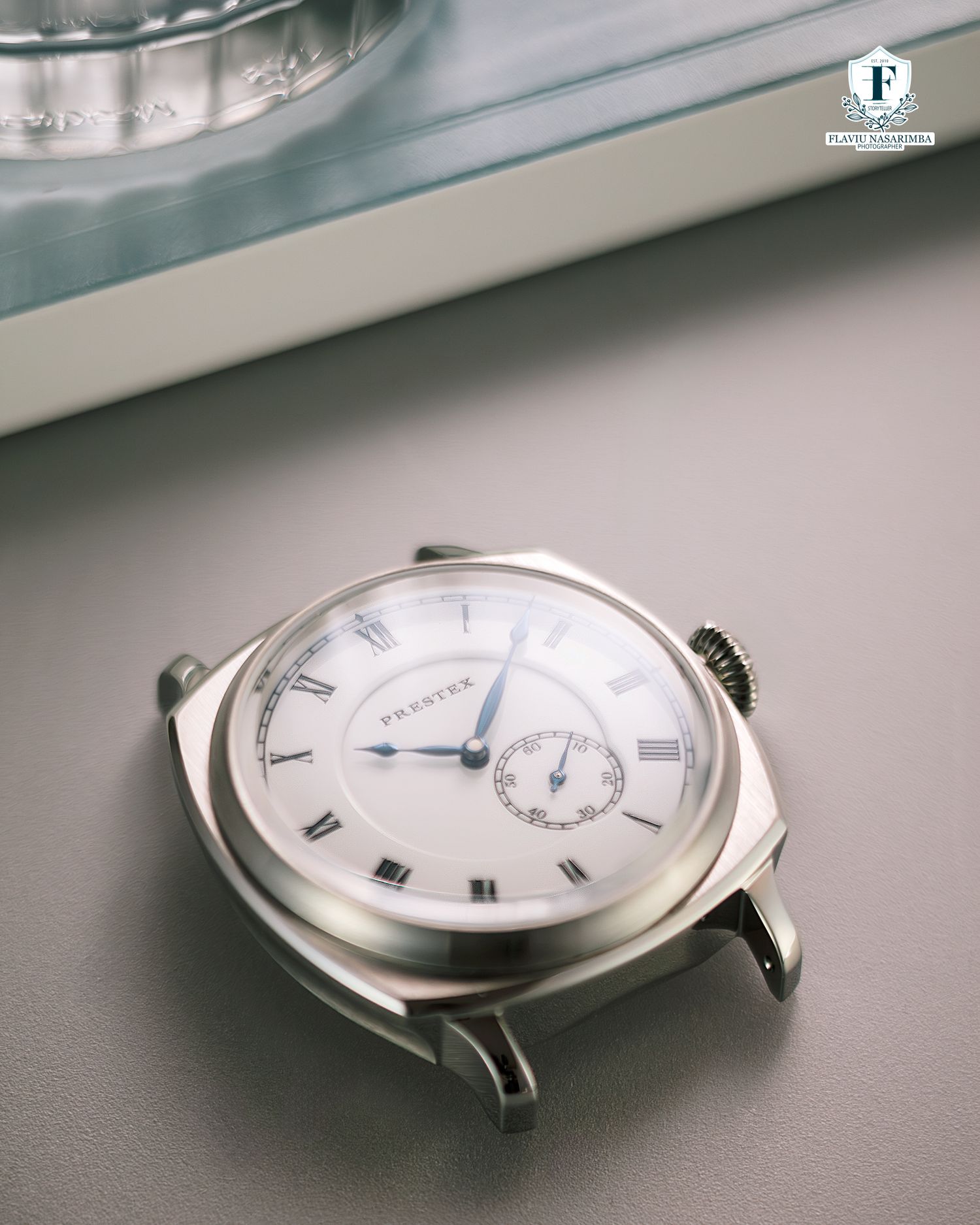 Praesus cushion-case dress watch with white enamel dial and blued hands, no strap.