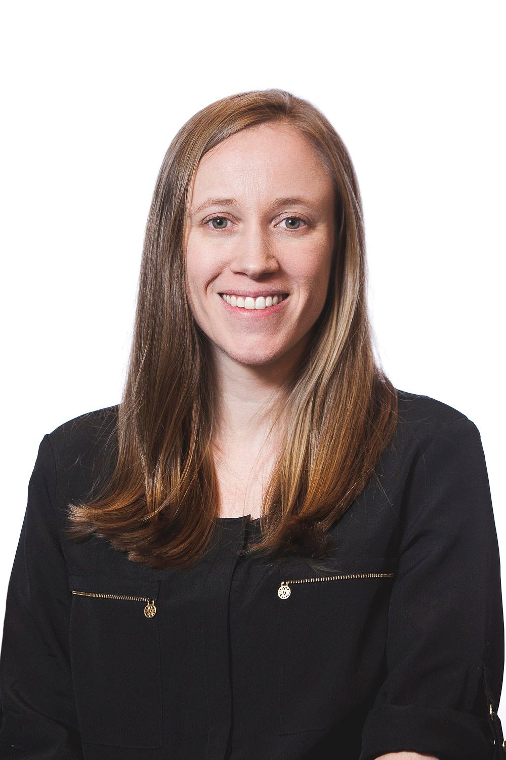 Professional headshot of a smiling woman with long brown hair wearing a black blazer on white background.