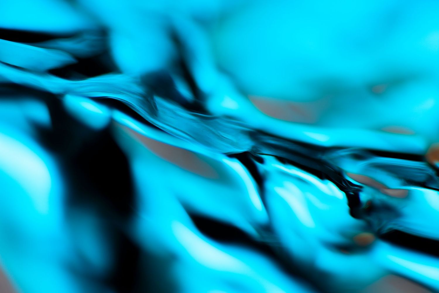 Abstract cyan and black liquid water surface with flowing reflective ripples and glossy metallic texture in vivid blue tones.