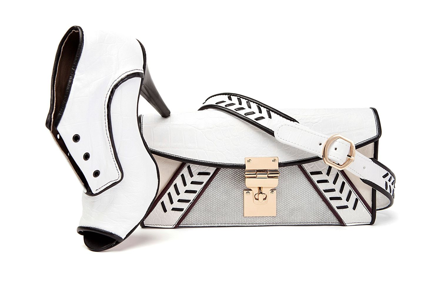 White and black leather high heel boot paired with matching structured clutch bag with gold hardware.