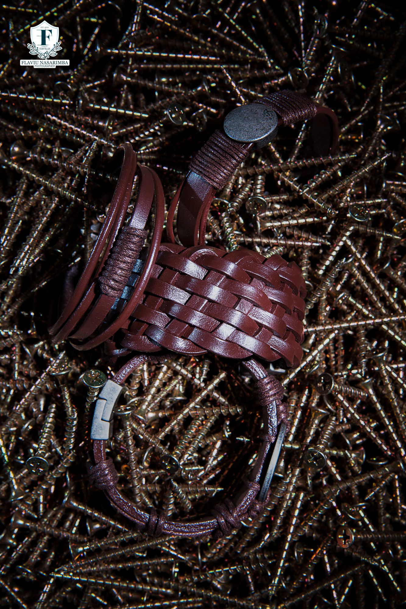 Brown woven leather bracelet with silver clasp displayed on metal screws background.