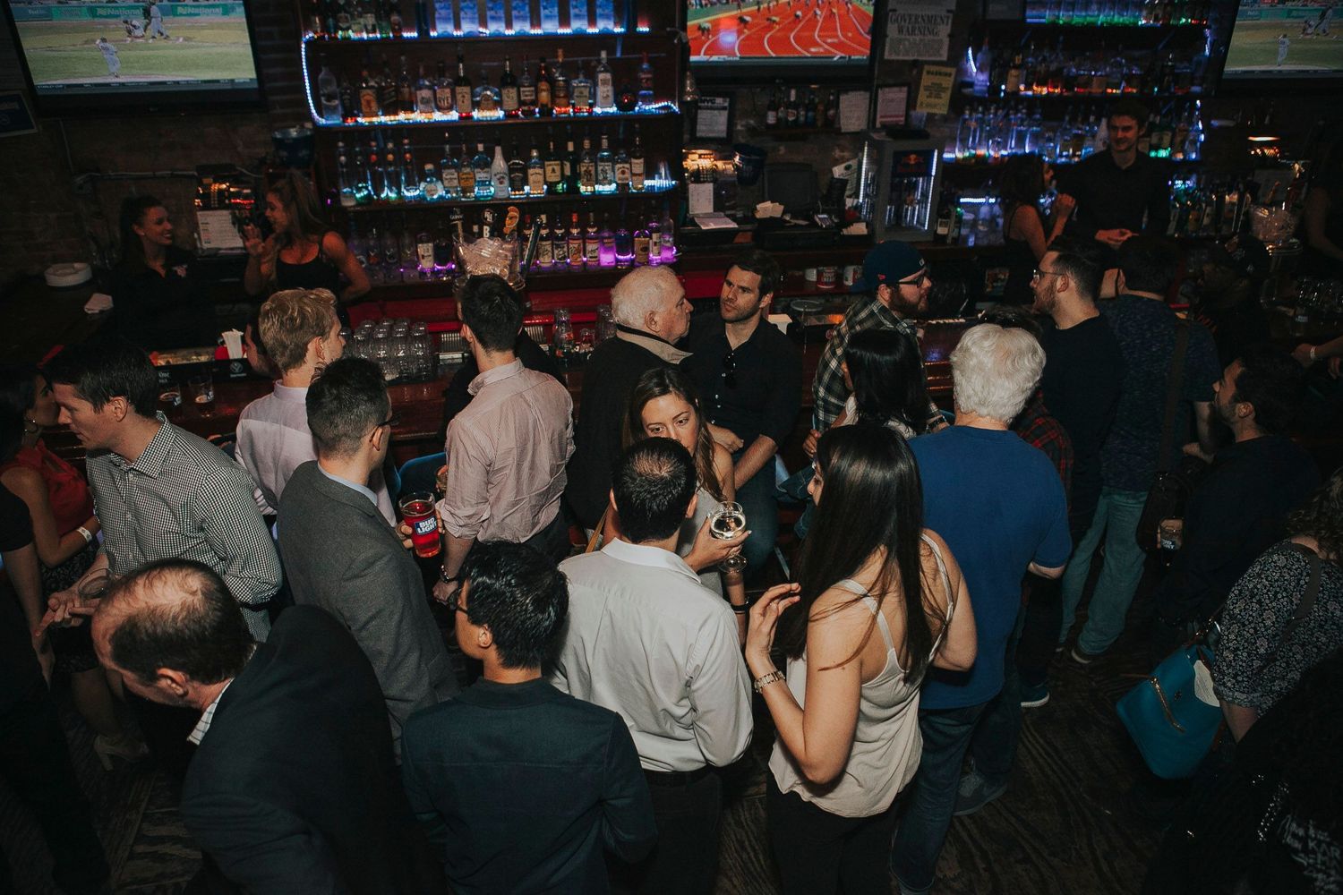 Overhead view of a packed bar with guests socializing during a networking event.
