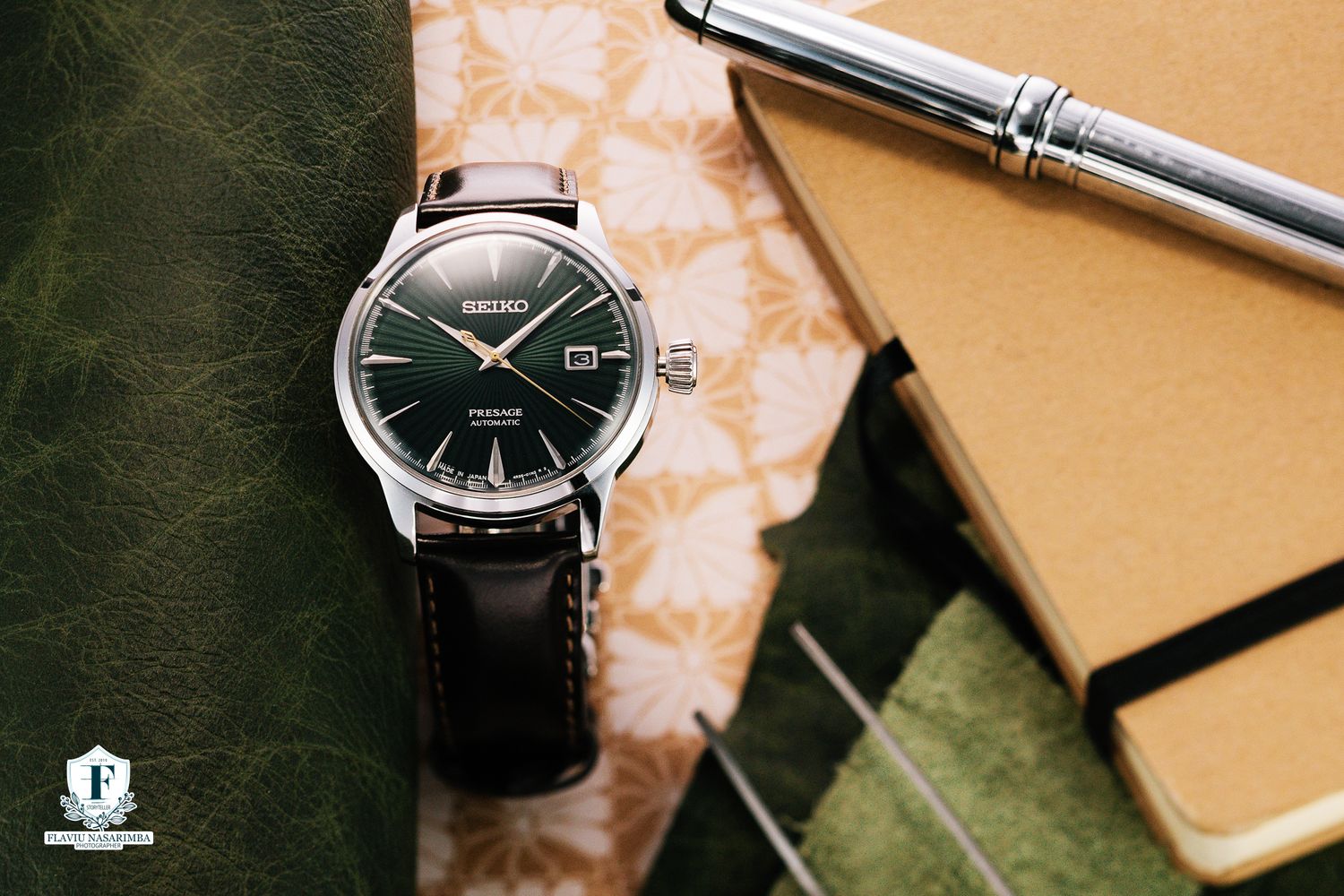 Seiko Presage automatic watch featuring a green sunburst dial on black leather strap with notebook and pen.
