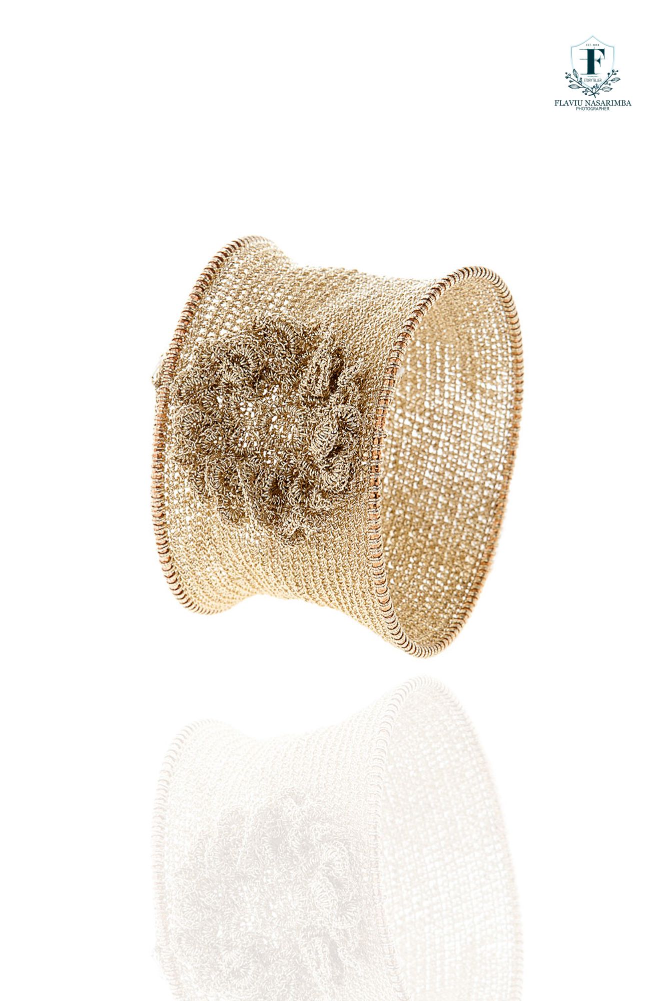 Wide gold mesh cuff bracelet with woven wire texture and decorative floral rosette centerpiece.