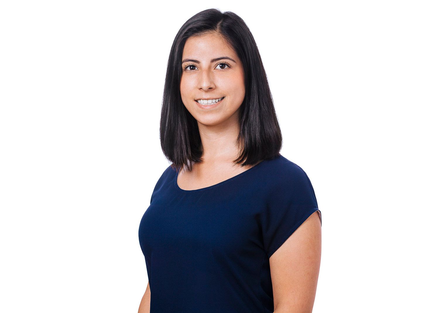 Professional headshot of a smiling woman with dark hair wearing a navy blue top on white background.