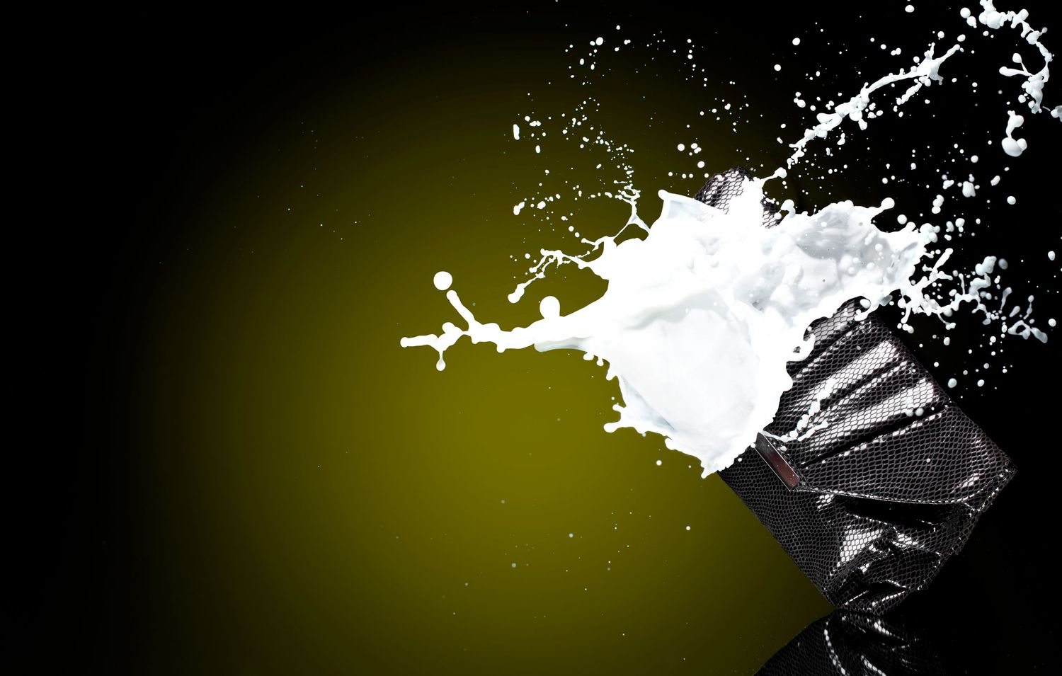 Dynamic milk splash bursting from a black container against a dark olive green background.