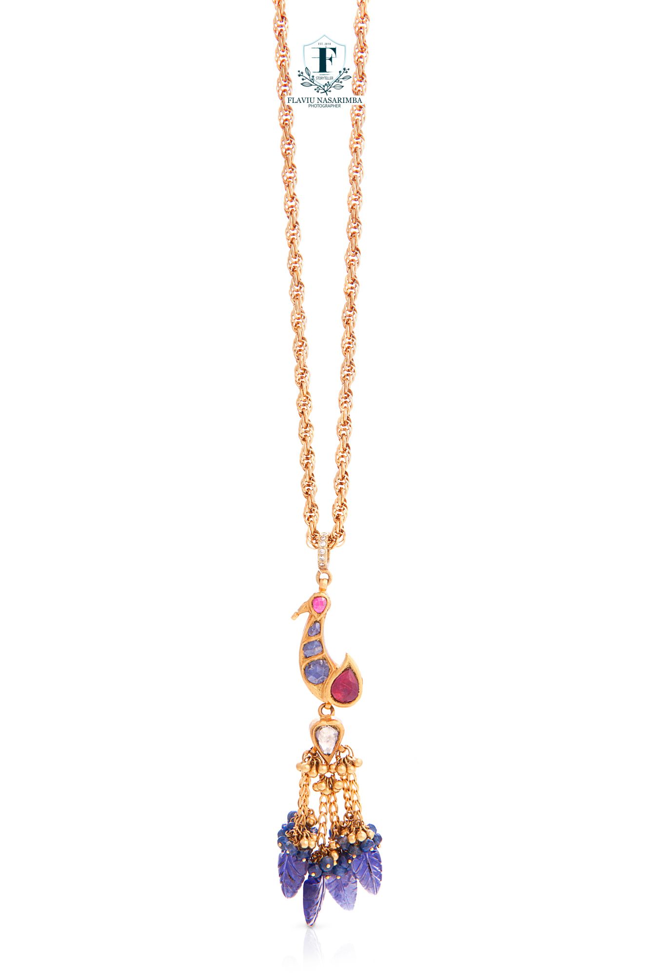 Rose gold rope chain necklace with peacock pendant featuring ruby, amethyst drops, and gold bead tassels.