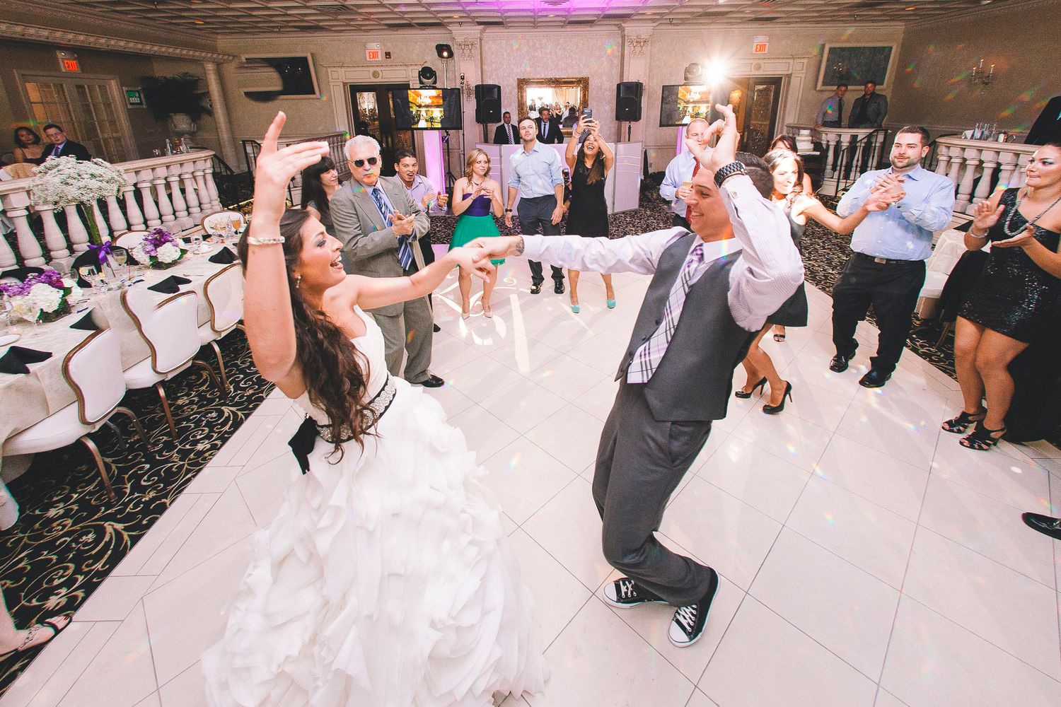 Bride and father share an energetic dance together on the wedding reception dance floor.