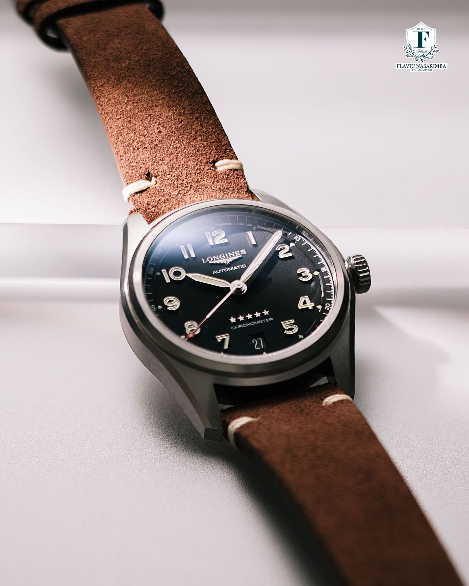 Longines Spirit automatic watch with black dial and Arabic numerals on brown leather strap.