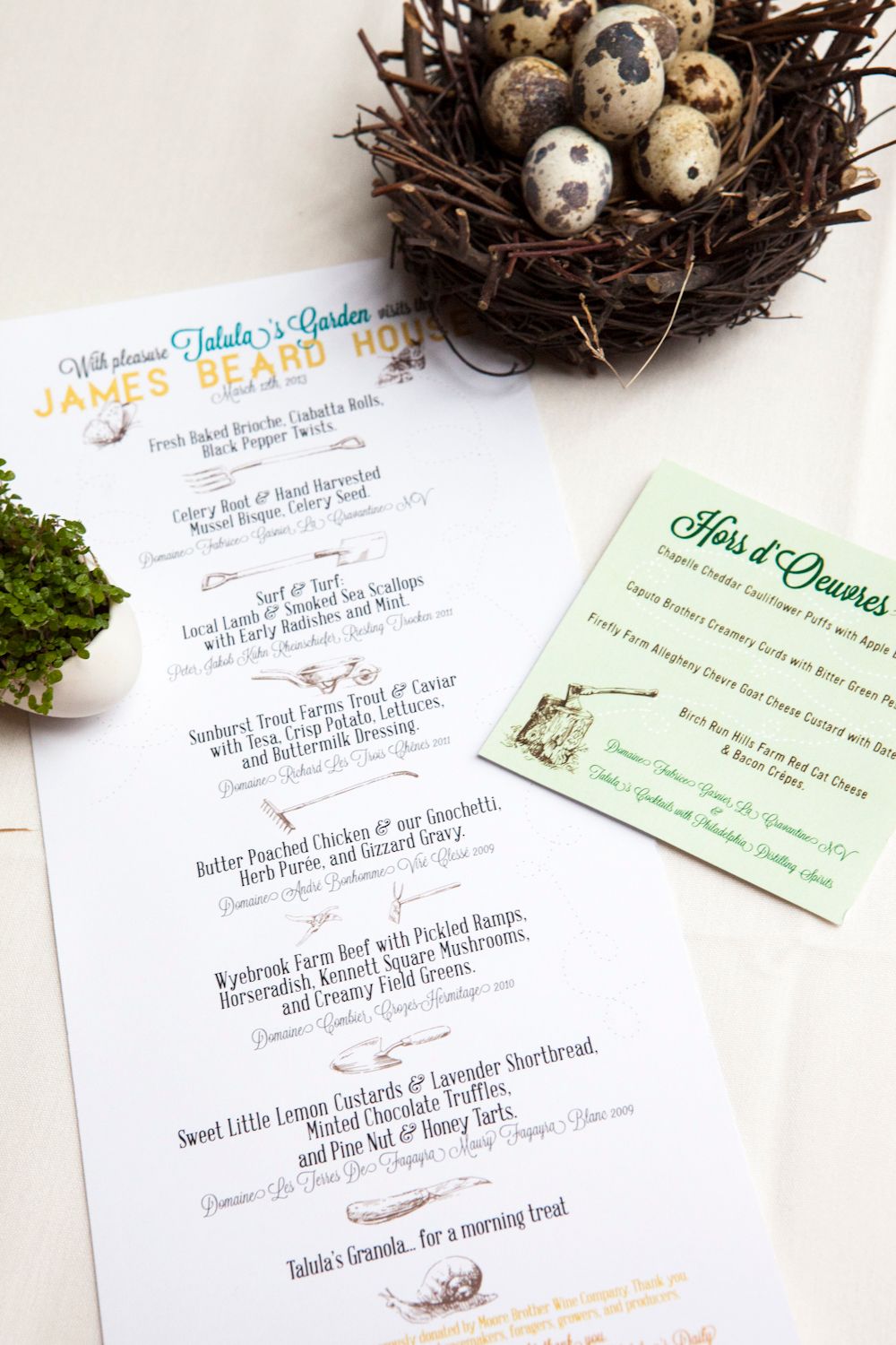 James Beard House dinner menu cards displayed beside a rustic bird nest with speckled eggs.