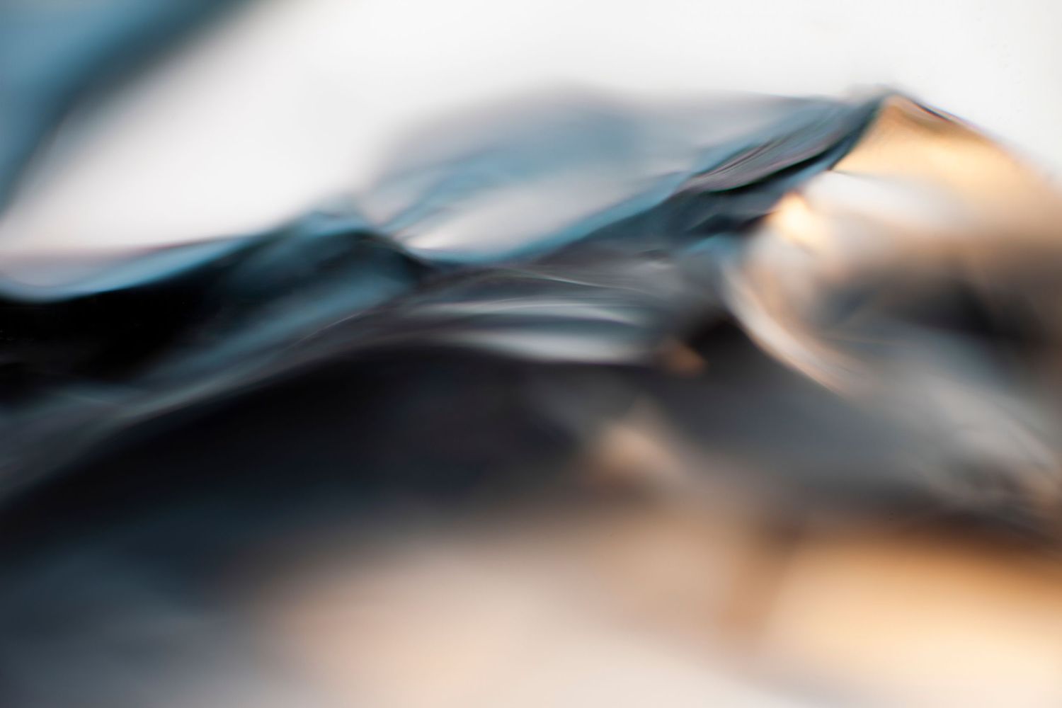 Abstract close-up of dark blue and gold metallic surfaces with soft bokeh blur effect.