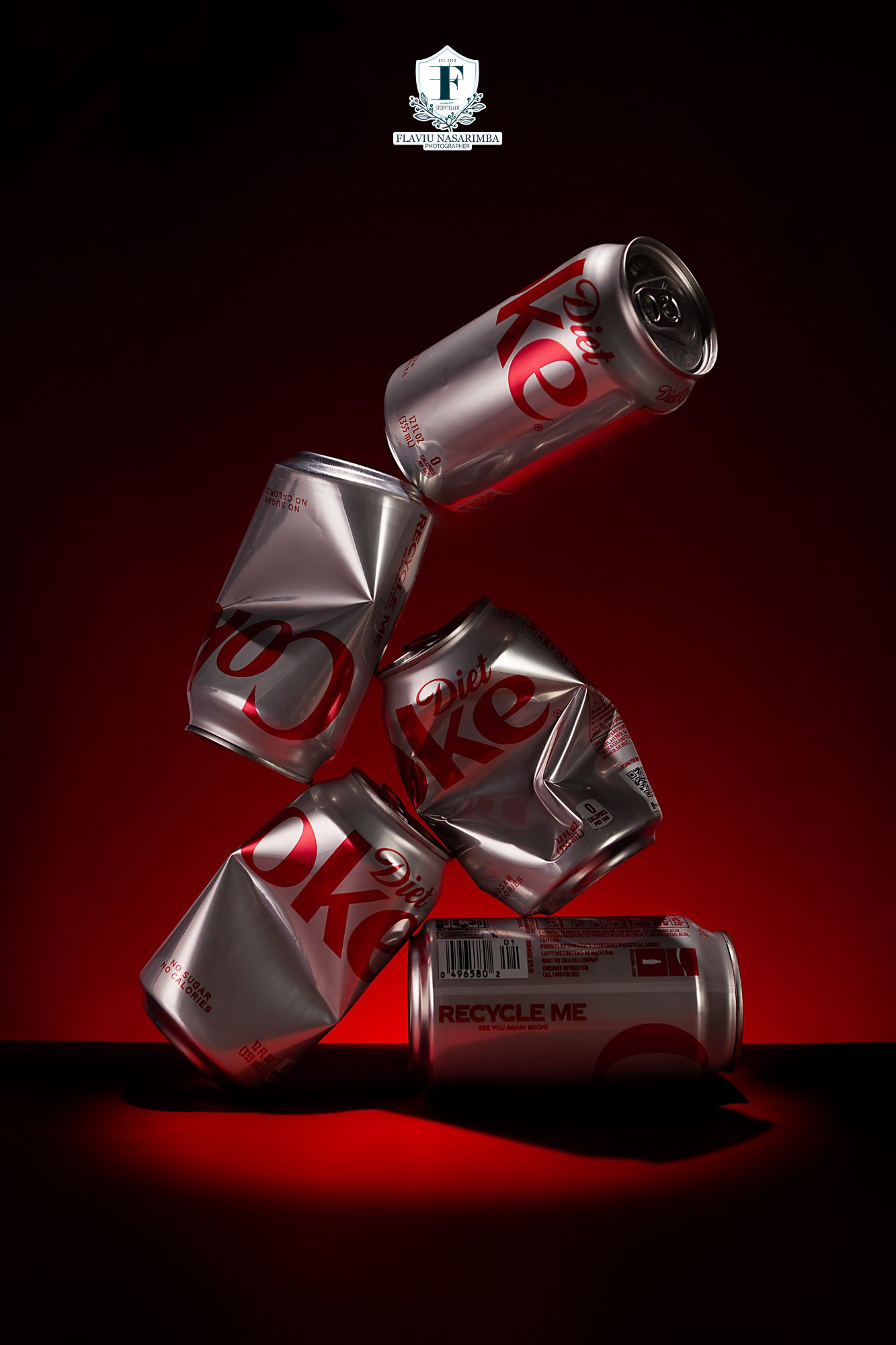 Crushed Diet Coke cans stacked in dynamic arrangement against dramatic red and black background.