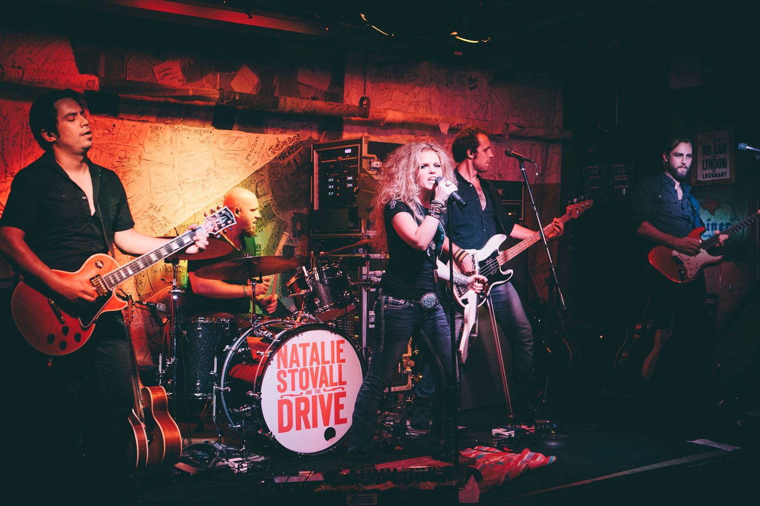 Natalie Stovall Drive band performing live on stage with electric guitars and dynamic lighting.