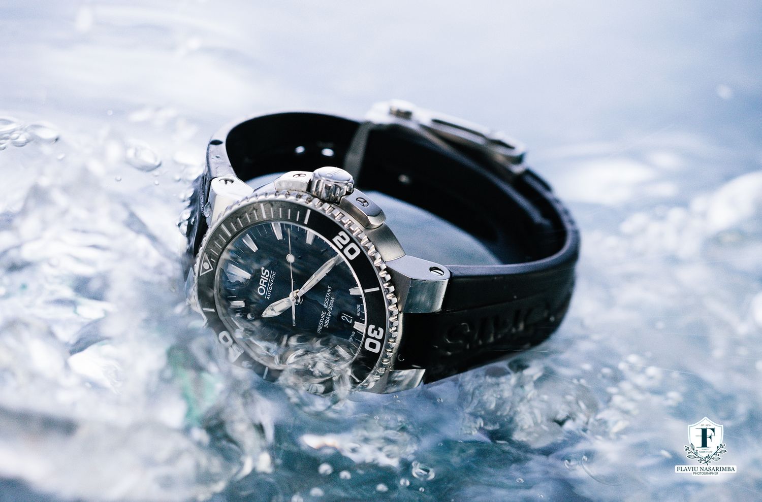 A sleek black diving watch with rubber strap resting on ice and water, showcasing its water-resistant design.