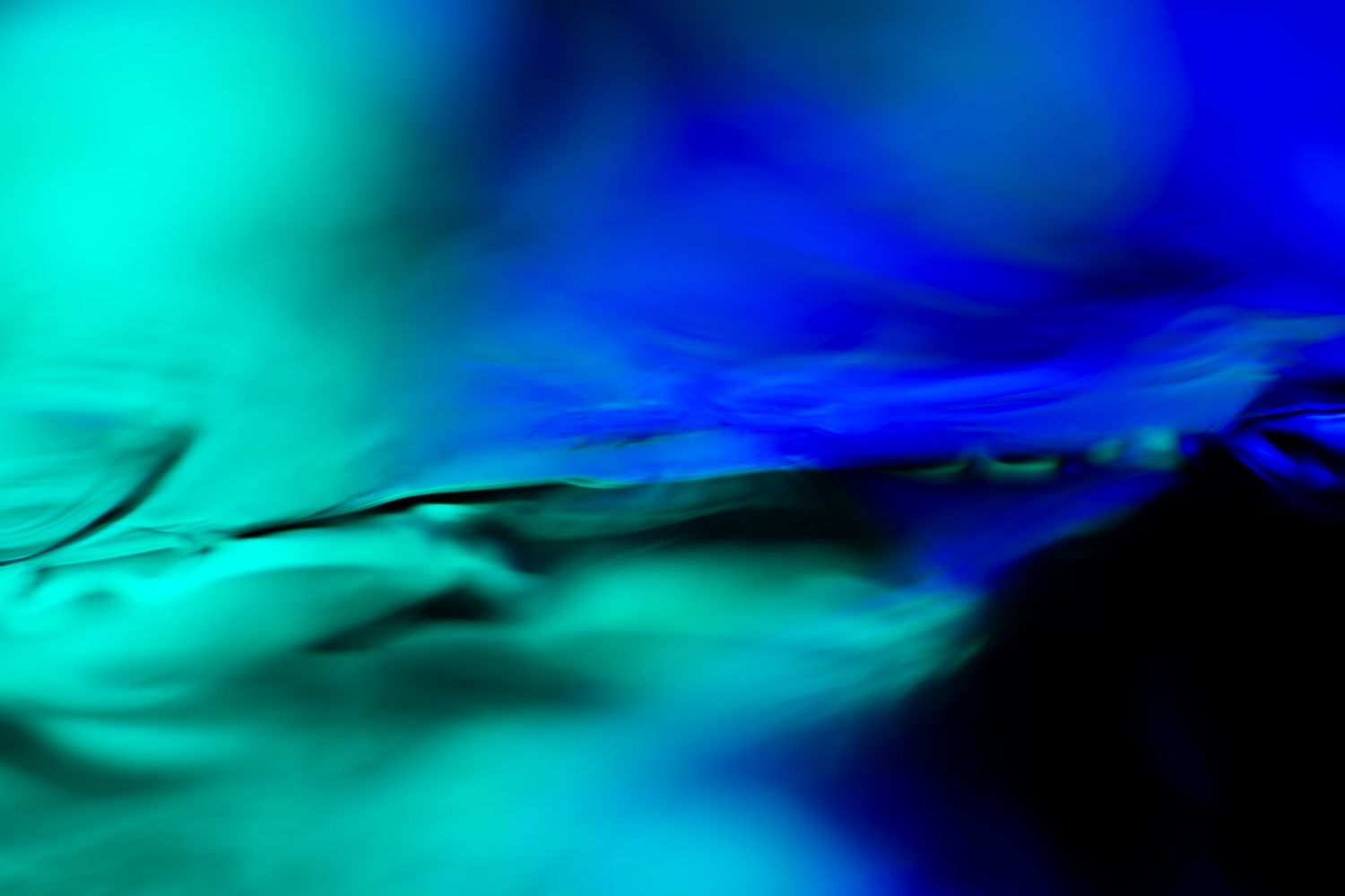 Abstract blue and teal liquid art with swirling colors creating a vivid, dynamic fluid motion background.