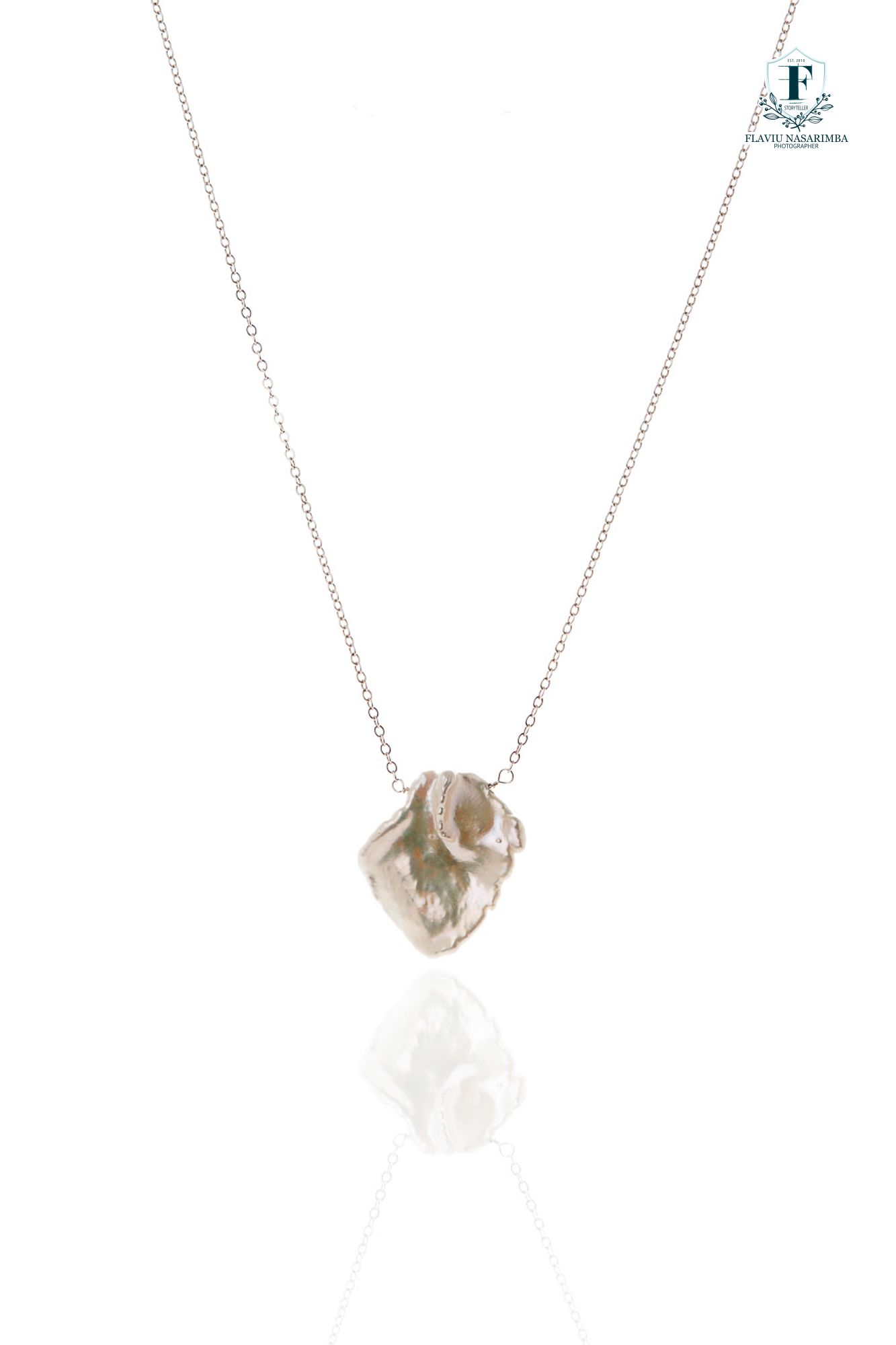 Delicate silver chain necklace with a large baroque pearl pendant accented by small diamond details.