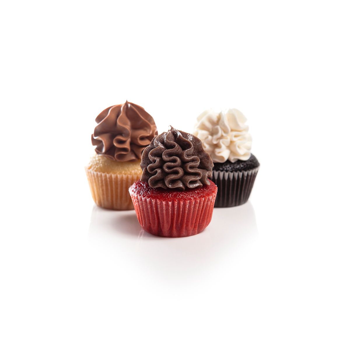 Four assorted mini cupcakes with chocolate and vanilla frosting in decorative cupcake liners.