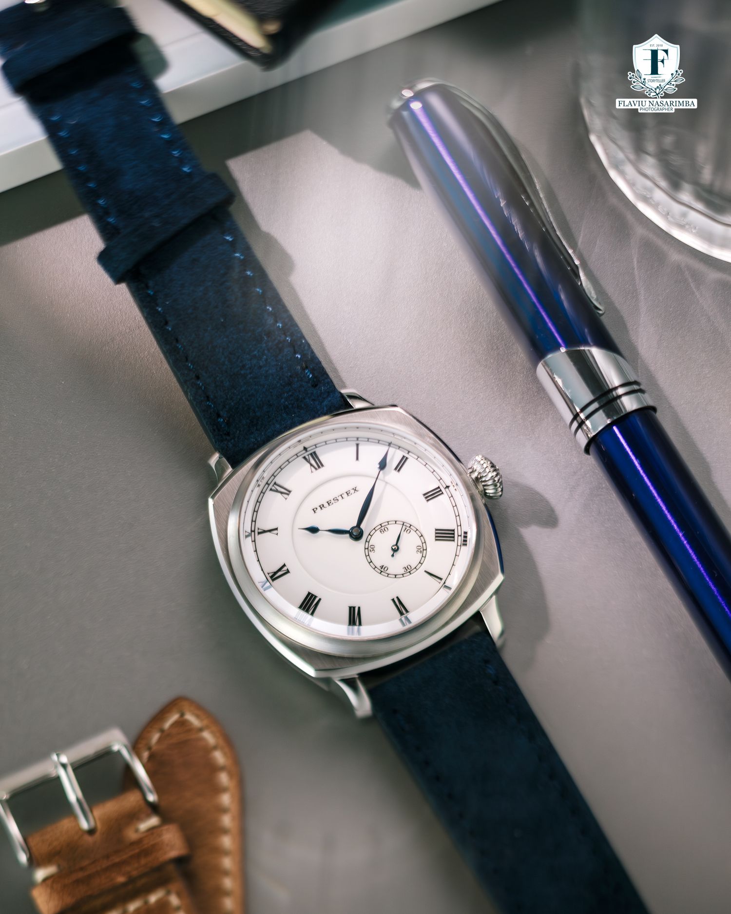 Praesus dress watch with white dial and Roman numerals on navy blue suede strap.