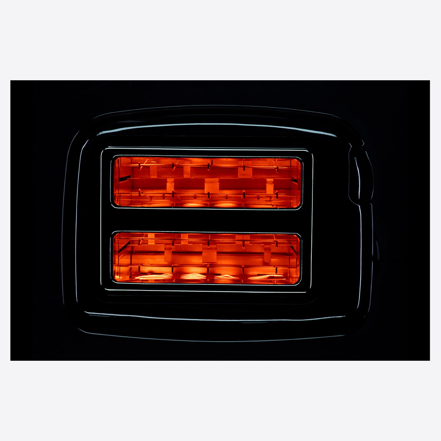 Close-up of a glowing toaster with bright orange heating elements illuminated against a dark background.